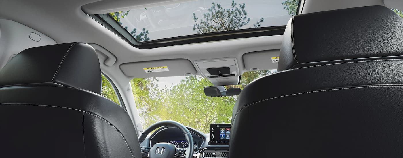 The interior of a 2022 Honda Civic shows the front center console from the back seats.