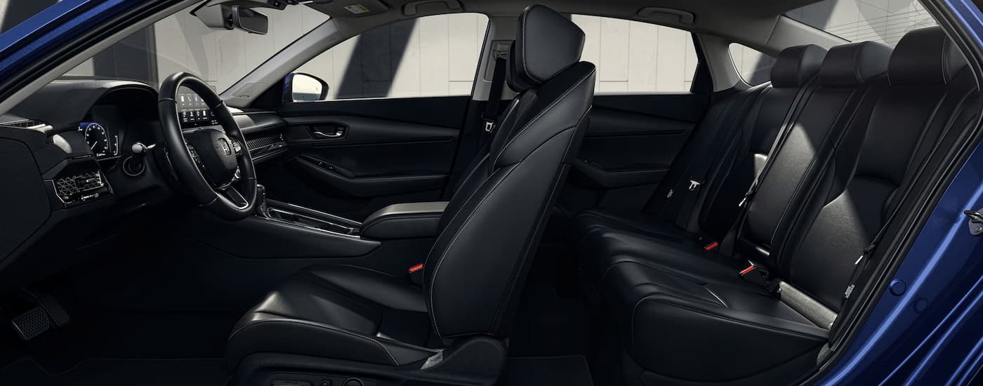 The black interior of a blue 2023 Honda Accord is shown from the side during a 2023 Honda Accord vs 2023 Toyota Camry comparison.