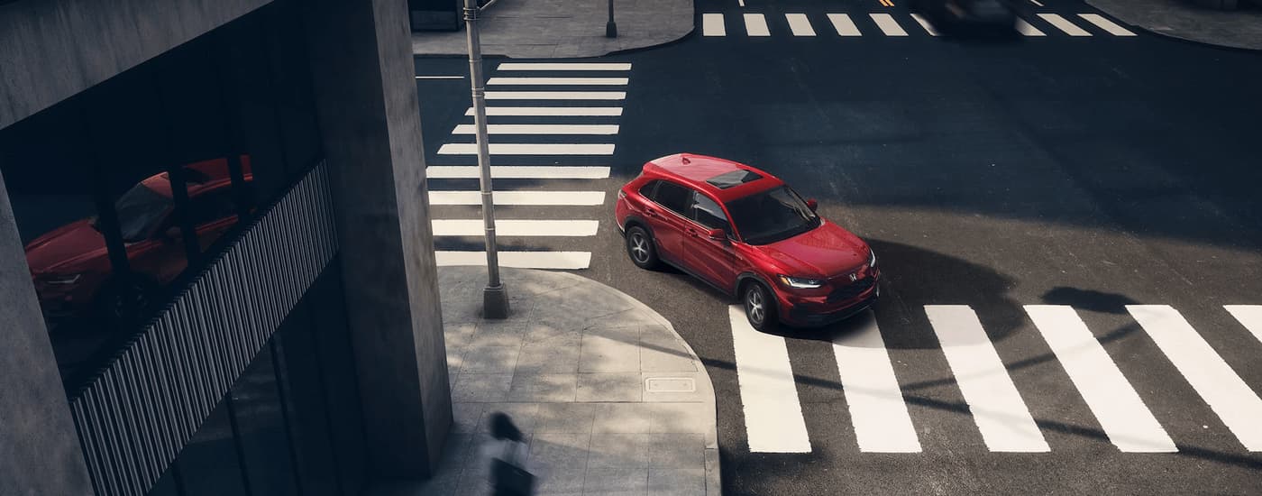 A red 2023 Honda HR-V is shown turning onto a city street.