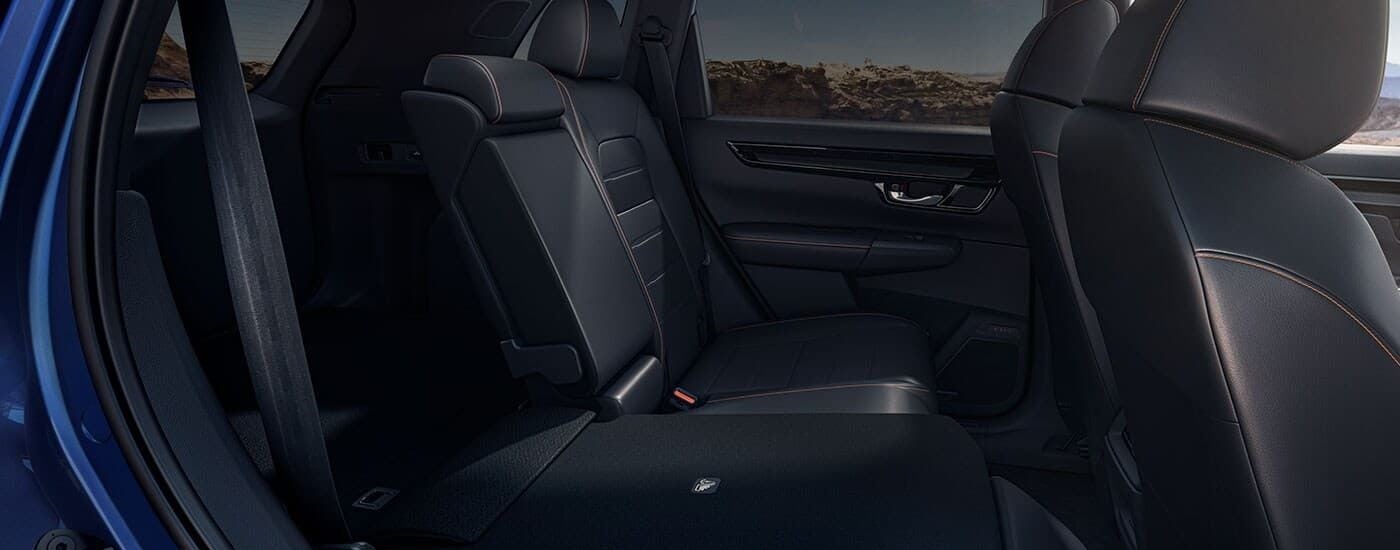 The black interior of a 2024 Honda CR-V Sport Touring Hybrid shows the rear-folding seats.