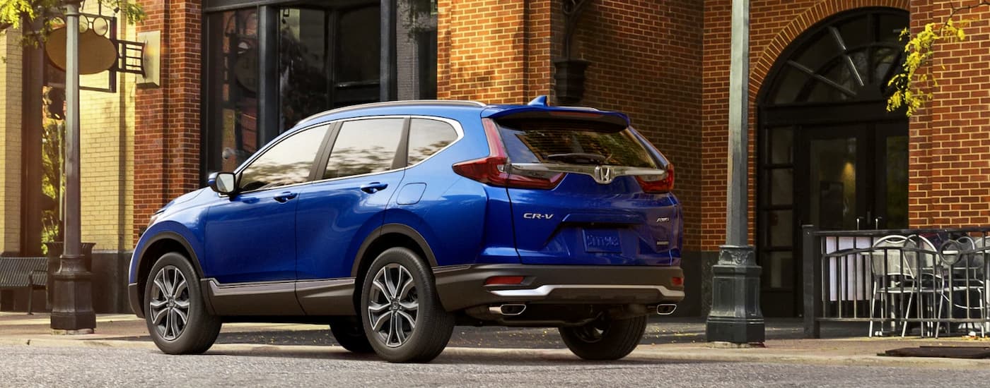 A blue 2022 Honda CR-V is shown from a rear angle on a city street after leaving a Honda CR-V dealer.