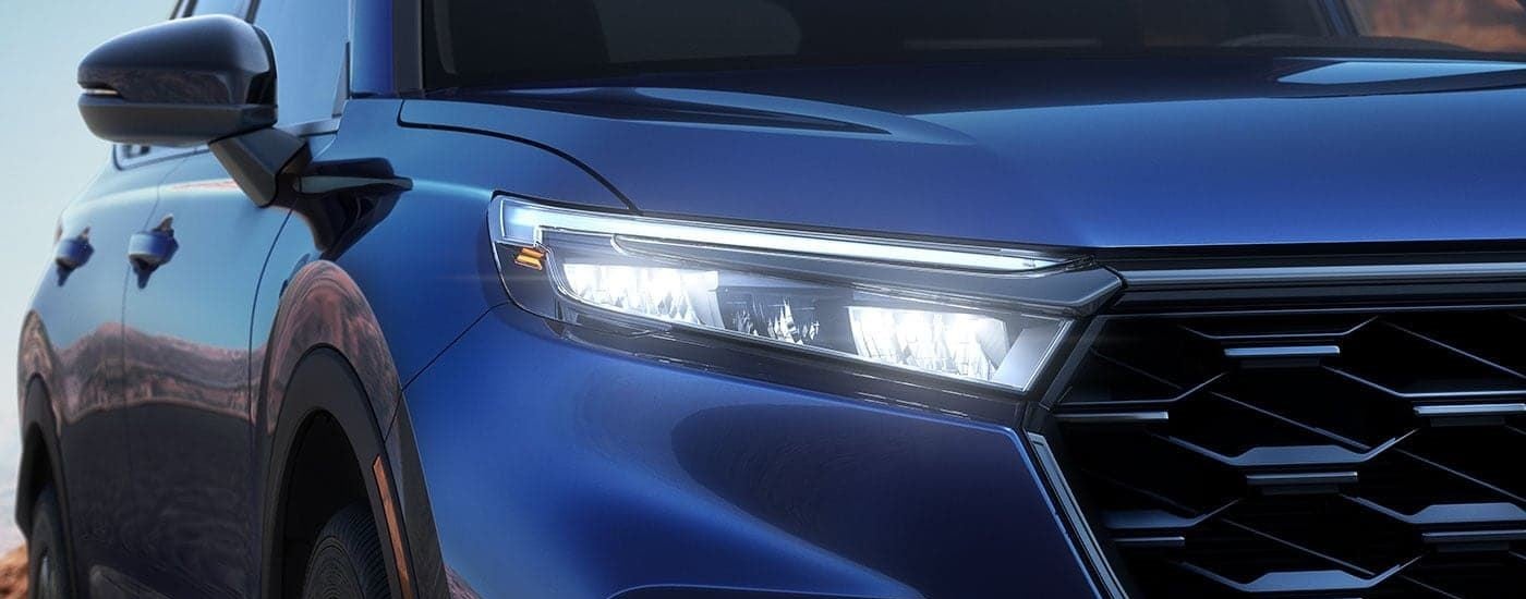 A close up of the grille on a blue 2023 Honda CR-V is shown.